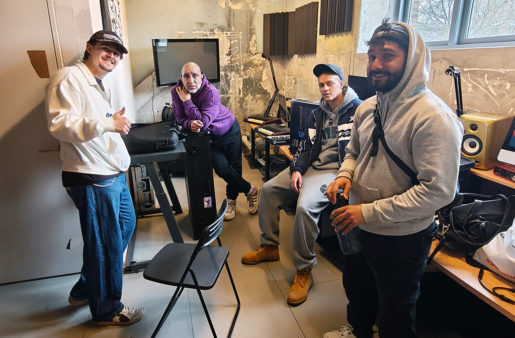 Fire mandlige musikere i kælderrum med AV-udstyr